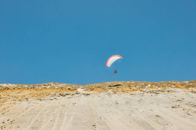IMAGO Creative: Sport Dichotomien - Land und Wasser Young man paragliding during summer off cliffs in Baja, Mexico. Baja California, Chis., Mexico CR_JUSLKY200806-466790-01 ,model released, Symbolfoto