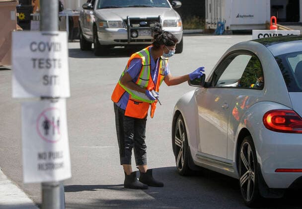 (200814) -- VANCOUVER, Aug. 14, 2020 -- A worker shows the direction of the line-up area to a driver at the entrance to a COVID-19 testing facility in Vancouver, British Columbia, Canada, on Aug. 14, 2020. British Columbia s COVID-19 curve is now climbing at a higher rate than the initial outbreak in March, and new provincial modelling shows B.C. could see a second wave bigger than the first by September. (Photo by Xinhua) CANADA-VANCOUVER-COVID-19-TEST LiangxSen 