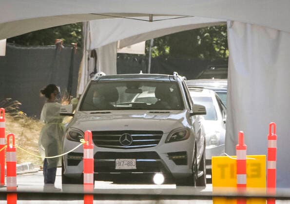(200814) -- VANCOUVER, Aug. 14, 2020 -- A healthcare worker speaks with a passenger inside a vehicle at a COVID-19 testing facility in Vancouver, British Columbia, Canada, on Aug. 14, 2020. British Columbia s COVID-19 curve is now climbing at a higher rate than the initial outbreak in March, and new provincial modelling shows B.C. could see a second wave bigger than the first by September. (Photo by Xinhua) CANADA-VANCOUVER-COVID-19-TEST LiangxSen 