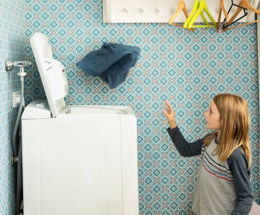 IMAGO Creative: Frühjahrsputz Girl Throwing Laundry Into Washing Machine in Helsinki, Finland Finland, Helsinki CR_EMWIXA200814-474256-01 ,model released, Symbolfoto