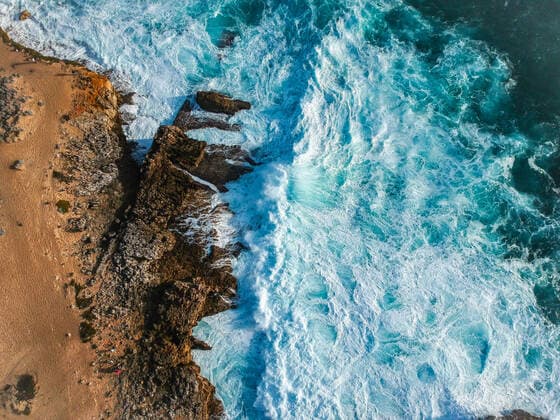 Aerial top view of sea waves hitting rocks on the beach with turquoise Cascais, Lisbon, Portugal CR_NUVA200814E-474610-01