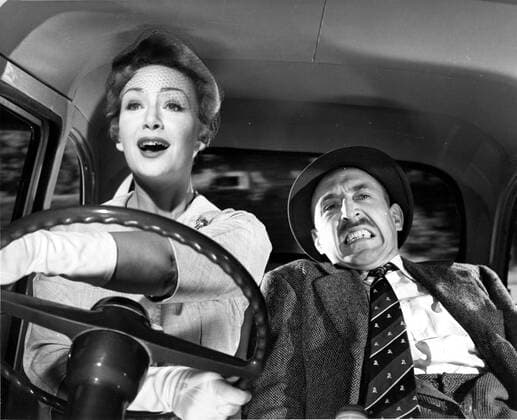 PLEASE TURN OVER ANGLO-AMALGAMATED PRODUCTIONS JEAN KENT, LIONEL JEFFRIES women driving bad. Strictly editorial use only in conjunction with the promotion of the film. Credit line mandatory. This image is copyright of the film company and is supplied under the terms of issue as film still. No commercial or book cover use permitted without prior consent from the film company.  Mandatory credit line: Image courtesy Ronald Grant Archive Mary Evans
