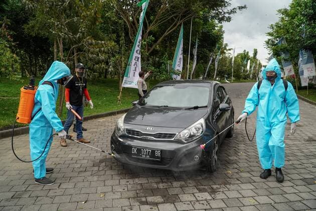 August 17, 2020, Gianyar, Bali, Indonesia: Workers spray the spectator s car with disinfectant. First drive-in music concert in Bali held in Ubud region amid Covid-19 coronavirus outbreak to encourage Bali musicians to keep productive and having health mentality after 5 months pandemic period. The spectators sllowed to be outside the car which still inside each boundary line. Gianyar Indonesia - ZUMAb245 20200817_zip_b245_029 Copyright: xDickyxBisinglasix