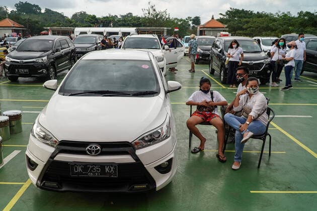 August 17, 2020, Gianyar, Bali, Indonesia: Spectators sits next to their car. First drive-in music concert in Bali held in Ubud region amid Covid-19 coronavirus outbreak to encourage Bali musicians to keep productive and having health mentality after 5 months pandemic period. The spectators sllowed to be outside the car which still inside each boundary line. Gianyar Indonesia - ZUMAb245 20200817_zip_b245_031 Copyright: xDickyxBisinglasix