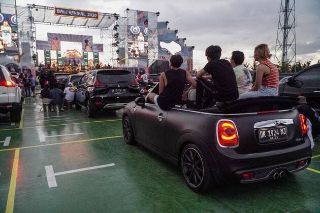 August 17, 2020, Gianyar, Bali, Indonesia: Spectators sits on their opened car s roof while watching the concert. First drive-in music concert in Bali held in Ubud region amid Covid-19 coronavirus outbreak to encourage Bali musicians to keep productive and having health mentality after 5 months pandemic period. The spectators sllowed to be outside the car which still inside each boundary line. Gianyar Indonesia - ZUMAb245 20200817_zip_b245_043 Copyright: xDickyxBisinglasix