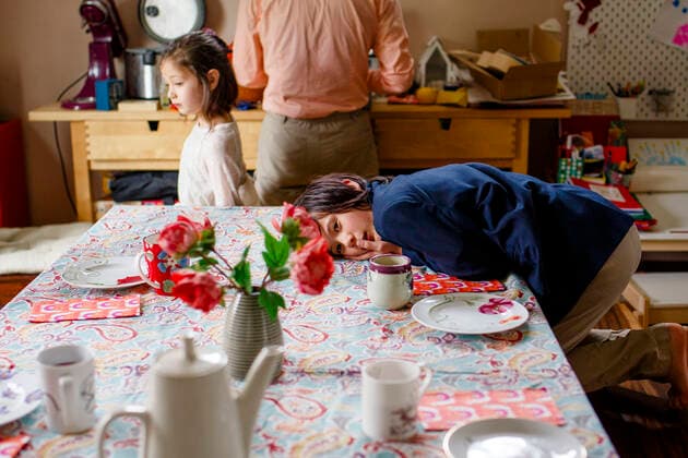 IMAGO Creative, Ostern, Bräuche, Osterbrunch A boy in a suit lays across a table set for tea, family in background Columbus, OH, United States CR_RETI200811-423425-01 ,model released, Symbolfoto