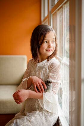 IMAGO Creative: Jahreszeit Winter, Fantasievoll drinnen spielen A small happy child with missing tooth holds a baby chick in her arms Columbus, OH, United States CR_RETI200811-423450-01 ,model released, Symbolfoto