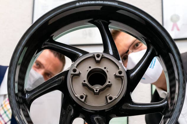 18.08.2020 Deutschland,Sachsen,Kesselsdorf: Staatsminister Martin Dulig am 18.8.2020 schaut beim Besuch der thyssenkrupp Carbon Components GmbH Kesselsdorf anlässlich der Auszeichnung im Innovationswettbewerb mit dem TOP 100-Award gemeinsam mit Geschäftsführer Dr. Jens Werner durch eine in dem Betrieb gefertigte Felge. Das Unternehmen entwickelt Produkte für den Leichtbau - zum Beispiel ultraleichte, geflochtene Carbonfelgen für Autos und Motorräder sowie Bewehrungsstäbe aus Carbon für den Betonbau, die in ersten Pilotprojekten in Sachsen erprobt werden.