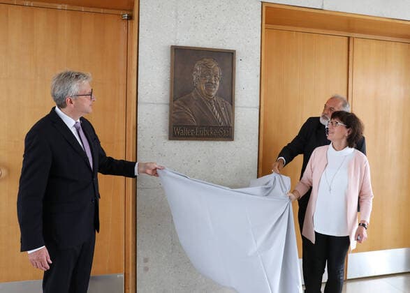 Zum Gedenken an dem am 2. Juni 2019 mutmasslich von einem Rechtsextremisten ermordeten Kasseler Regierungspraesidenten Walter Luebcke (Lübcke) wurde am Freitag (21.08.2020) vor dem grossen Sitzungssaal eine Bronzetafel mit dem Konterfei des Verstorbenen enthuellt, die der aus Afghanistan stammende Kuenstler Berahna Massoum geschaffen hat. Zugleich wurde der Saal in Walter-Luebcke-Saal umbenannt (Foto v.li.: v.l. Hermann-Josef Klueber (Regierungspraesident Kassel), Irmgard Braun-Luebcke (Witwe von Walter Luebcke), Berahna Massoum (Kuenstler). (Siehe epd-Meldung vom 21.08.2020) Bronzetafel erinnert an Walter Luebcke