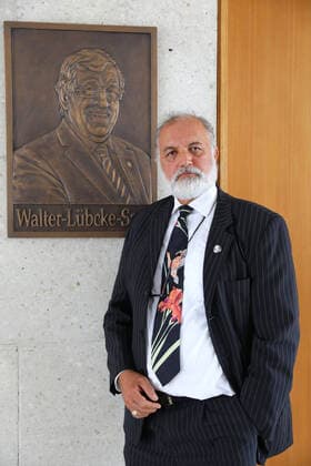 Kuenstler Berahna Massoum vor der Bronzetafel (Foto vom 21.08.2020). Zum Gedenken an dem am 2. Juni 2019 mutmasslich von einem Rechtsextremisten ermordeten Kasseler Regierungspraesidenten Walter Luebcke (Lübcke) wurde am Freitag (21.08.2020) vor dem grossen Sitzungssaal eine Bronzetafel mit dem Konterfei des Verstorbenen enthuellt, die der aus Afghanistan stammende Kuenstler Berahna Massoum geschaffen hat. Zugleich wurde der Saal in Walter-Luebcke-Saal umbenannt (Foto v.li.: v.l. Hermann-Josef Klueber (Regierungspraesident Kassel), Irmgard Braun-Luebcke (Witwe von Walter Luebcke), Berahna Massoum (Kuenstler). (Siehe epd-Meldung vom 21.08.2020) Bronzetafel erinnert an Walter Luebcke