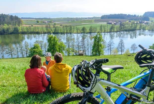 Radtour am Bodensee Eine Radtour mit den Kindern im Frühling am Bodensee zwischen Lindau und Kressbronn. Junge Familie genießt den Ausflug während der Obstbaumblüte an einem sonnigen Tag im April schöner Platz für eine Pause beim Radeln Lindau Bodensee-Region Bayern Deutschland