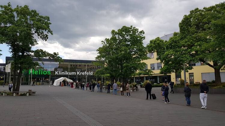 Feature Symbol: Auf Corona-Test Wartende 06 20 pp Schlange von Wartenden auf Corona-Test vor Helios-Klinikum in Krefeld im Juni 2020 Deutschland deutsch deutsche Stadt Klinik Krankenhaus Virus testen lassen Warteschlange Abstand Abstandsregel haltend Testzentrum Testzelt quer