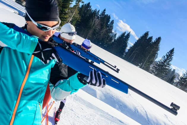 Wintersportler beim Biathlon Freizeit-Biathleten beim Schießen mit einem Lasergewehr an einem kalten und sonnigen Wintertag Das Biathlon-Gewehr im Anschlag Sulzberg Nordic Zentrum Vorarlberg Österreich *** Winter sportsmen at the biathlon Leisure time Biathletes shooting with a laser rifle on a cold and sunny winter day The biathlon rifle at the attack Sulzberg Nordic Center Vorarlberg Austria