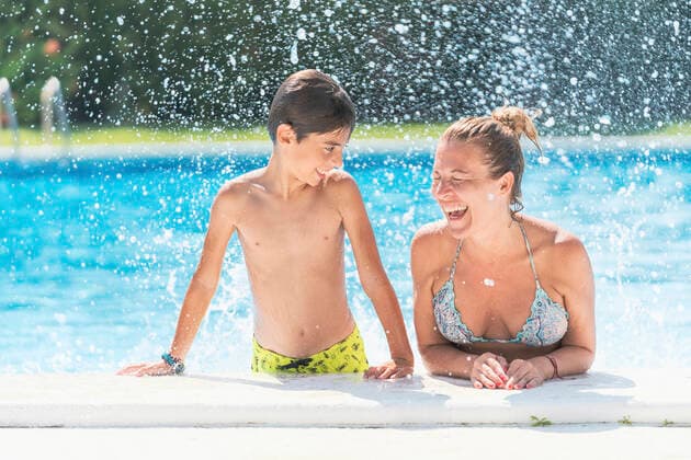Shirtless boy looking at mother laughing in swimming pool model released Symbolfoto DLTSF00905