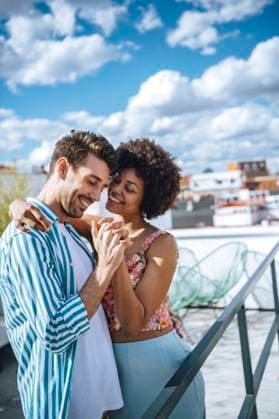 Happy multi-ethnic couple dancing on penthouse patio model released Symbolfoto property released EHF00608