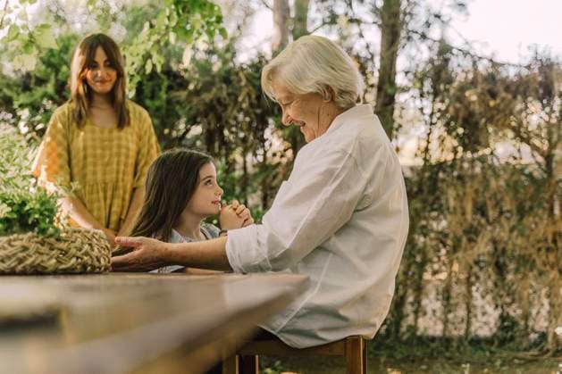 IMAGO Creative: Sommer, Sommertage im Garten Woman looking at senior woman playing with cute granddaughter in yard model released Symbolfoto property released ERRF04190