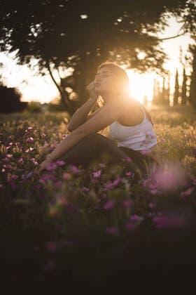 Boring teenager sitting in the field among flowers at sunset San Martín de la Vega, Community of Madrid, Spain CR_DIRR200818C-447696-01 ,model released, Symbolfoto