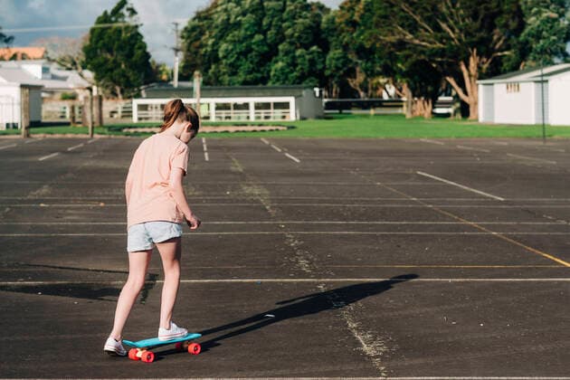 Young girl on a skateboard alone at a basketball court Hawera, Taranaki, New Zealand CR_LVBS200818-468786-01 ,model released, Symbolfoto