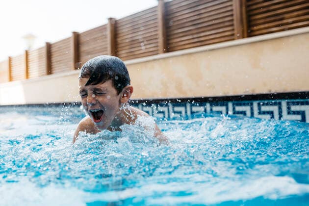 Boy enjoying in swimming pool during summer model released Symbolfoto property released JRFF04689