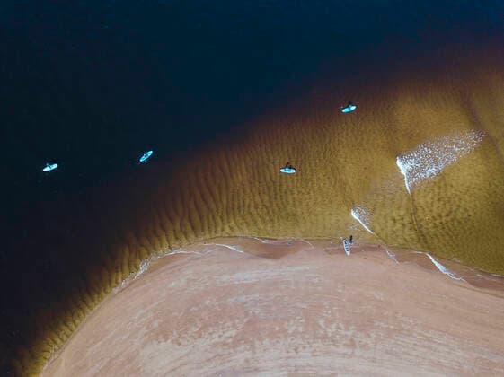 IMAGO Creative: Sommer Sport - Strand Aerial view of people surfing in coastal waters of Barents Sea model released Symbolfoto KNTF04949