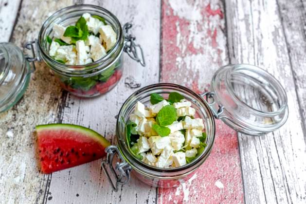Watermelon slice and jars of watermelon salad with feta cheese, corn salad and mint SARF04608