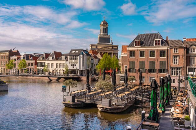 Netherlands, South Holland, Leiden, Restaurant on Nieuwe Rjin river canal with Hartebrugkerk in background TAMF02566