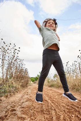Cheerful girl jumping on land against cloudy sky model released Symbolfoto VEGF02535