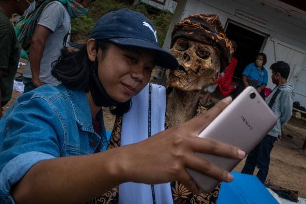 IMAGO Cultures of the world, Toraja Volk in Indonesien August 25, 2020, Nort Toraja, South sulawesi, Indonesia: IIN ARENSIA taking a selfie with his grandfather preserved body NE POTTA during a traditional ritual called Manene in Panggala, Nort Toraja, South Sulawesi, Indonesia, Tuesday, August 25th. The ritual is held every three years when family members gather to clean the graves and change the clothes of their deceased relatives to honor their spirits. The ritual is held before the planting season arrives. Nort Toraja Indonesia - ZUMAh421 20200825_zip_h421_012 Copyright: xHariandixHafidx