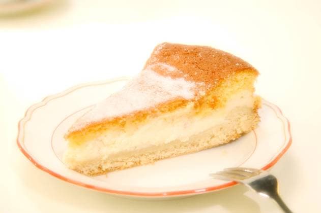 Die Dresdner Eierschecke (Knetteig mit Quarkmasse, darauf eine dickschaumigen Mischung aus saurer Sahne, Ei und Vanillezucker), zaehlt zu den typisch saechsischen Spezialitaeten, und wird natuerlich mit einer Tasse Bohnenkaffee auf Meissner Porzellan serviert. Dresden Sachsen GERMANY *** The Dresdner Eierschecke kneaded dough with curd mixture, on top of a thick foamy mixture of sour cream, egg and vanilla sugar, is one of the typical Saxon specialities, and is of course served with a cup of coffee on Meissen porcelain Dresden Sachsen GERMANY