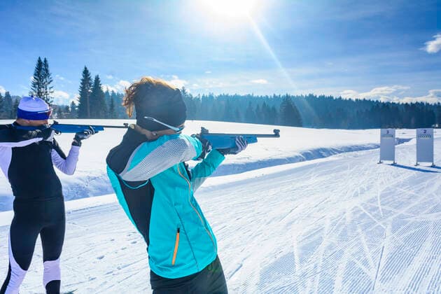 Wintersportler beim Biathlon Freizeit-Biathleten beim Schießen mit einem Lasergewehr an einem kalten und sonnigen Wintertag Wintersportler beim Schießen mit dem Biathlongewehr Sulzberg Nordic Zentrum Vorarlberg Österreich *** Winter sportsmen at biathlon Leisure biathletes shooting with a laser rifle on a cold and sunny winter day Winter sportsmen shooting with a biathlon rifle Sulzberg Nordic Center Vorarlberg Austria