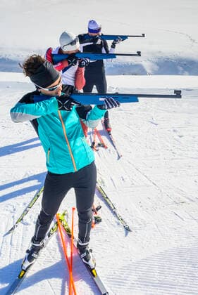 Wintersportler beim Biathlon Freizeit-Biathleten beim Schießen mit einem Lasergewehr an einem kalten und sonnigen Wintertag Drei Biathleten Sulzberg Nordic Zentrum Vorarlberg Österreich *** Winter sportsmen at the biathlon Recreational biathletes shooting with a laser rifle on a cold and sunny winter day Three biathletes Sulzberg Nordic Center Vorarlberg Austria