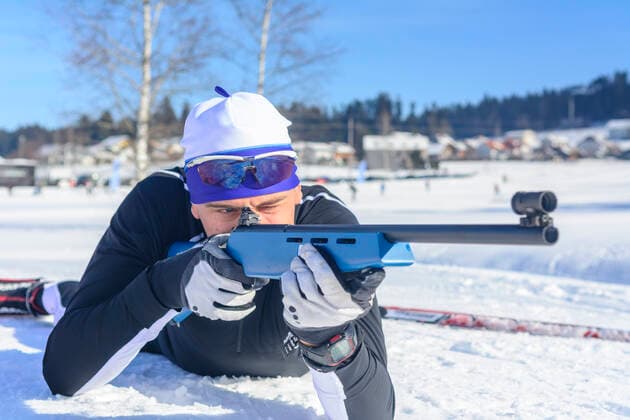 Wintersportler beim Biathlon Freizeit-Biathleten beim Schießen mit einem Lasergewehr an einem kalten und sonnigen Wintertag Biathlet beim Anvisieren der Scheiben im Liegendanschlag Sulzberg Nordic Zentrum Vorarlberg Österreich *** Winter sportsmen at the biathlon Leisure biathletes shooting with a laser rifle on a cold and sunny winter day Biathlete aiming at the targets in the prone position Sulzberg Nordic Center Vorarlberg Austria