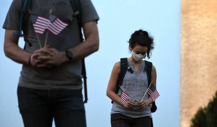 August 27, 2020, Washington, DC, USA: ALICE HAHN participates as The Covid Memorial Project holds a sunrise vigil with concerned citizens holding flags to symbolize 180,000 pandemic deaths in the U.S. near the Washington Monument in Washington DC on August 27, 2020. They planned to install the flags on the National Mall but were prevented by Park Police. The flag installation was to recognize and grieve for the loss of life that they believe was due to President Donald TrumpÃ¢â‚¬â ¢s poor handling of the response on this day that he will host the final night of the Republican National Convention at the White House. Washington USA - ZUMAg208 20200827_zap_g208_017 Copyright: xCarolxGuzyx