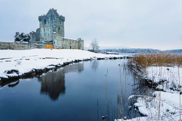 Ross Castle on the banks of Lough Leane in winter, covered in snow on a cloudy day; County Kerry, Ireland  Copyright: MichealxHoward 13491583