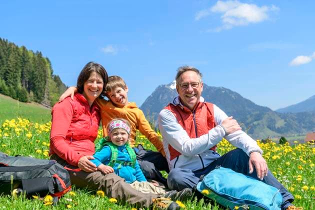 Familien-Tour auf einem Naturlehrpfad im Oberallgäu Familienwanderung im frühlingshaften Allgäu mit Schnee auf den Alpengipfeln und grünen saftigen Wiesen im Illertal, Maifeiertag an den Hängen der Hörnerkette. Glückliche Familie sitzt auf einer Wiese im Allgäu Ofterschwang Ofterschwang Bayern Deutschland *** Family tour on a nature trail in Oberallgäu Family hike in the springlike Allgäu with snow on the alpine peaks and green lush meadows in the Illertal, May Day on the slopes of the chain of horns Happy family sitting on a meadow in the Allgäu Ofterschwang Ofterschwang Bavaria Germany