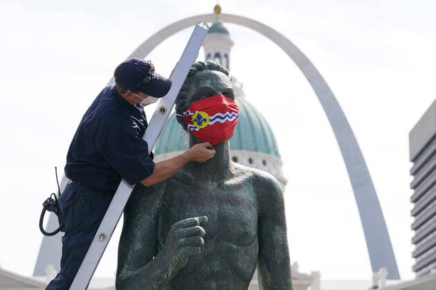 Bilder des Jahres 2020, News 09 September News Themen der Woche KW36 News Bilder des Tages St. Louis firefighter Charlie Hangge adjusts the St. Louis flag mask he just placed on The Runner , in Kiener Plaza in St. Louis on Thursday, September 3, 2020. The fire department is assisting the St. Louis Arts Chamber of Commerce, installing face coverings to a number of statues in the St. Louis area, pushing the message to wear masks to stop the spread of Covid.  SLP2020090301 BILLxGREENBLATT