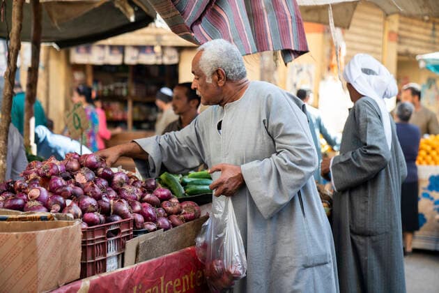 Egyptian male buying onions at a market Luxor, Luxor Governorate, Egypt CR_ALKA200904B-80460-01 EDITORIAL USE ONLY
