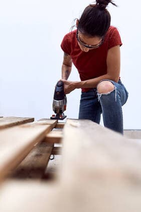 A young woman cutting wooden pallets with a jigsaw Madrid, Community of Madrid, Spain CR_NNSU200904-482203-01 ,model released, Symbolfoto