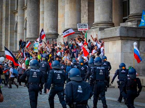 Polizisten rennen zu der Treppe vor dem Reichstag nachdem die Kundgebung vor dem Reichstag den sogenannten Sturm auf dem Reichstag proklamiert hatten und mehrere Absperrungen durchbrochen hatten und nun vor dem Reichstag eine Revolution fodert und außerdem mehrfach die Reichsflagge geschwenkt wird. Versammlung für die Freiheit - Berlin invites Europe am 29.08.2020 in Berlin *** Policemen running to the stairs in front of the Reichstag after the rally in front of the Reichstag had proclaimed the so-called storm on the Reichstag and had broken through several barriers and now there is a revolution in front of the Reichstag and the Reich flag is waved several times Assembly for Freedom Berlin invites Europe on 29 08 2020 in Berlin