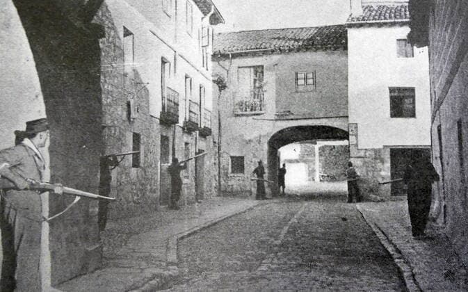 Black and white photograph from the Spanish Civil War (1936-1939); the taking of Santa Cruz de Retamar by Nationalists who advance with caution along the walls of the town. WorldxHistoryxArchive 917_33_WHA_134_0228