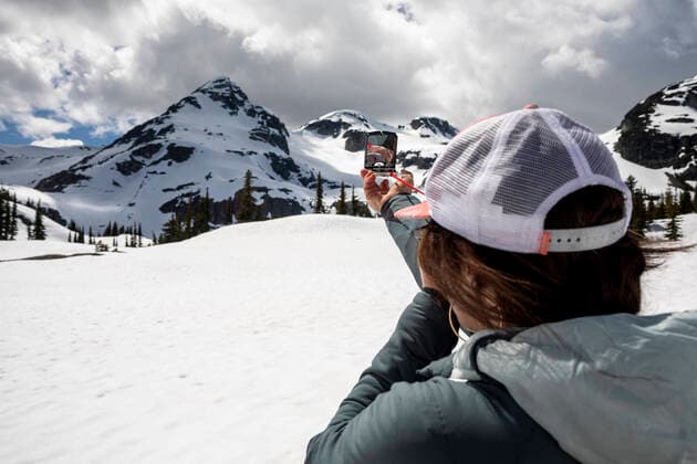 Anonymous woman using compass in snowy mountains Canada, British Columbia, Pemberton CR_PSFZ200913D-471364-01 ,model released, Symbolfoto