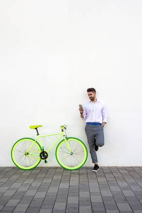 IMAGO Creative: Sport Start-Up Young bearded man leaning against a white wall using the mobile phone L Hospitalet de Llobregat, CT, Spain CR_RAFE200916A-462363-01 ,model released, Symbolfoto