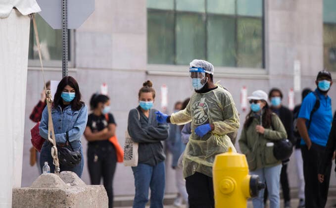 (200917) -- TORONTO, Sept. 17, 2020 -- A security officer wearing protective gear keeps order outside a COVID-19 assessment center in Toronto, Canada, on Sept. 17, 2020. The number of COVID-19 cases in Canada rose to 140,539 on Thursday, with 9,199 deaths, according to CTV. (Photo by Xinhua) CANADA-TORONTO-COVID-19-CASES ZouxZheng 