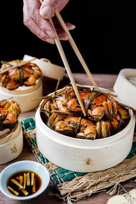 Chinese traditional cuisine in a steamer steamed Yangcheng Lake hairy crabs and seasoned vinegar ginger shreds in a dish. 779640030049599550