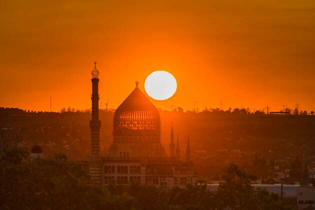Yenidze Sonnenuntergang hinter der Yenidze, Das ehemalige Fabrikgebäude der Zigarettenfabrik Yenidze gehört zu den architektonischen Sehenswürdigkeiten der Stadt Dresden. Es steht an der Weißeritzstraße am östlichen Rand der Friedrichstadt, unweit des Kongresszentrums. Das von 1908 bis 1909 von Martin Hammitzsch geplante Bauwerk hat eine Gesamthöhe von 62 Metern und wird heute als Bürogebäude genutzt. Dresden Sachsen GERMANY