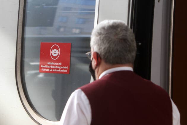 Aufkleber mit Piktogramm Maskenpflicht und Aufschrift Mitfahrt nur mit Mund-Nase-Bedeckung erlaubt an der Tür eines abfahrbereiten ICE Intercity Express der DB Deutsche n Bahn mit Maske tragendem Zugbegleiter im Hauptbahnhof Frankfurt, Hessen, Deutschland