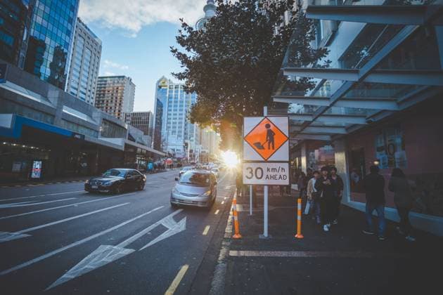 Photographed in the city of Auckland, New Zealand, the sun is setting, walking on the street, just the oblique light of the setting sun shines on the face, pedestrians on the side of the road are shopping, feel very comfortable.  809337839114256424