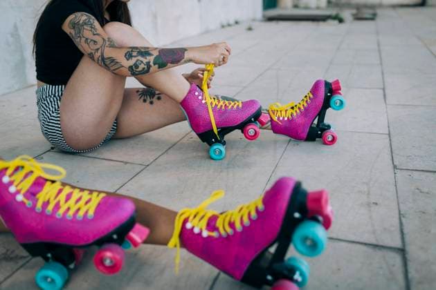 IMAGO Creative, Urban Lifestyle Low Section of friends with roller skates sitting on footpath model released Symbolfoto DCRF00701