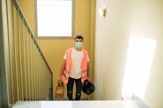 IMAGO Creative: 2021 Trends Delivery man with a mask during the new reality going upstairs model released Symbolfoto GMLF00504