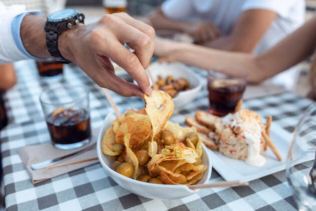 IMAGO Creative, Food, Tapas Cropped image of man having potato chip at cafe model released Symbolfoto property released JSRF01103